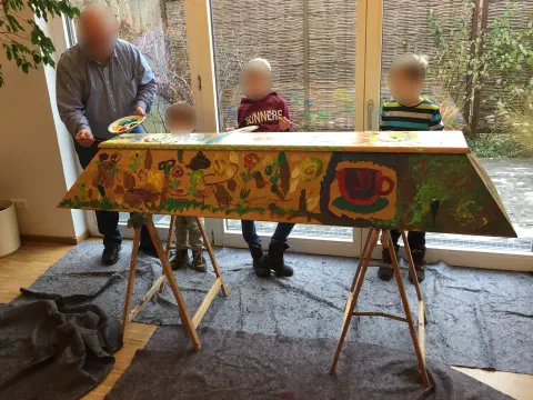 Familie präsentiert den fertig bemalten bunten Sarg