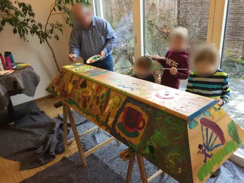 Fast fertiger bemalter Sarg mit Kaffeetasse, Gleitschirm und bunten Motiven