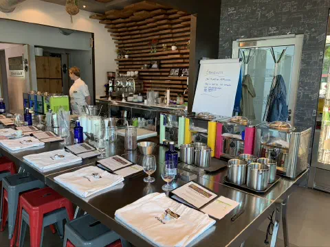 Kursraum mit Edelstahl-Arbeitsfläche, Töpfen und Flipchart mit Rezeptnotizen