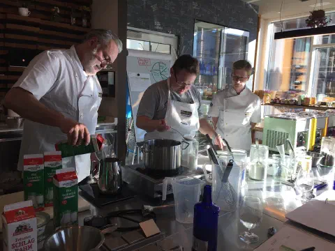 Kursleiter und Teilnehmer beim Erhitzen der Eismasse am Herd