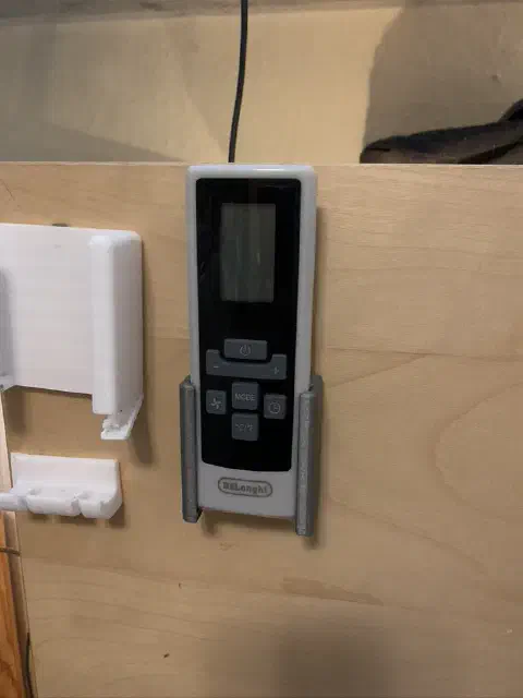 DeLonghi-Fernbedienung im Wandhalter neben Ladegerät