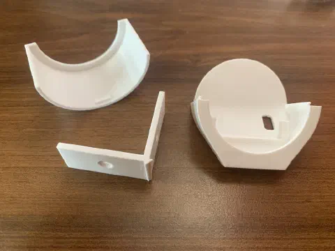 3D-gedruckte Einzelteile des Kamerahalters: Halbschale, Eckwinkel und zusammengestecktes Gehäuse