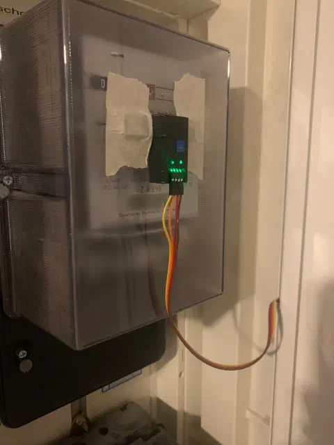 IR-Sensor mit leuchtenden LEDs am Ferraris-Stromzähler montiert