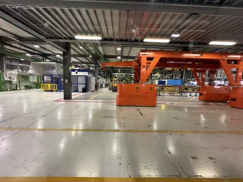 Große Industriehalle am CERN mit orangefarbenen Brückenkränen
