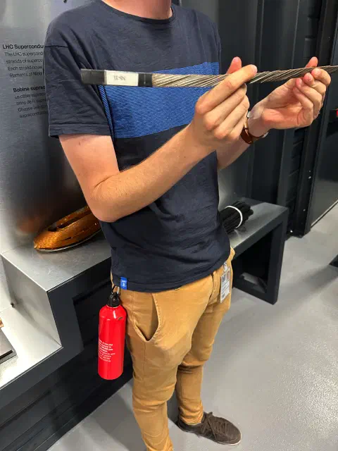 Physiker zeigt ein aufgefächertes supraleitendes Kabel aus Niob-Titan-Drähten
