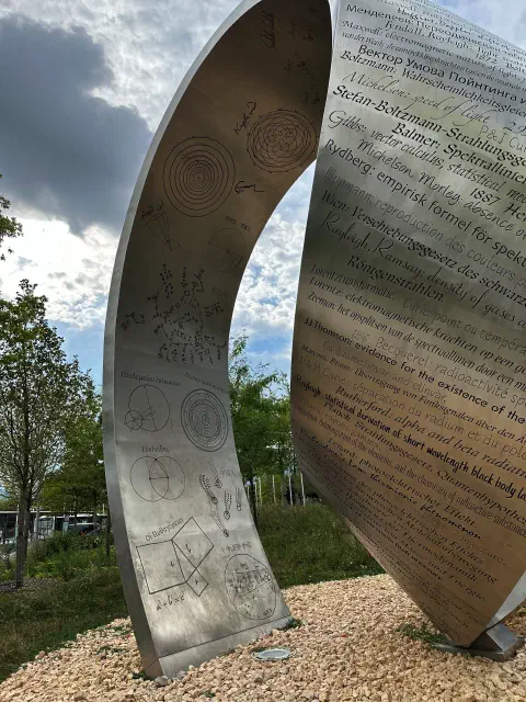 Nahaufnahme der Metallskulptur mit physikalischen Formeln am CERN