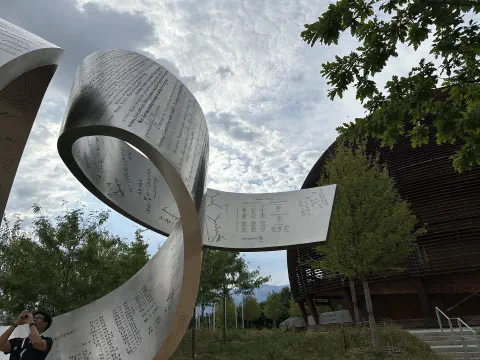 Metallskulptur vor dem kugelförmigen CERN Science Gateway
