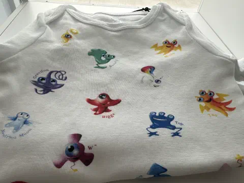 Baby-Body mit Elementarteilchen des Standardmodells aus dem CERN-Shop